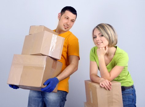 Professional movers carrying furniture through a narrow London entrance