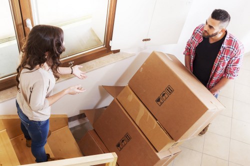 Removalists carrying household items through a central London building