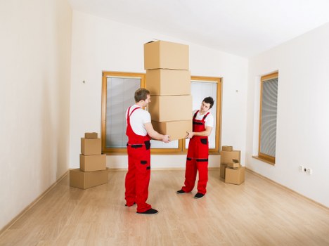 Professional movers handling furniture with a removal van in Soho