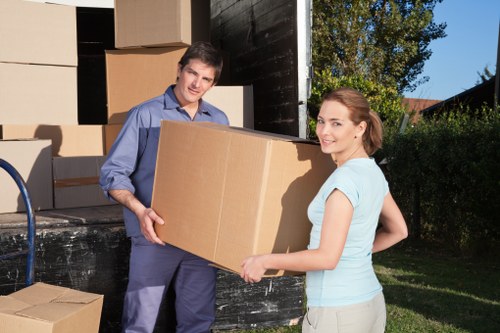 Professional movers carrying furniture through a central London property